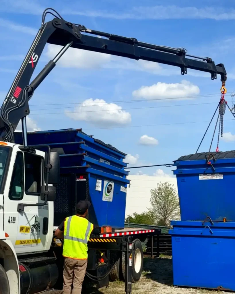 articulated crane truck lifting and separating nested dumpsters for transport and delivery from Georgia to North Carolina by Up! Up! Lifting